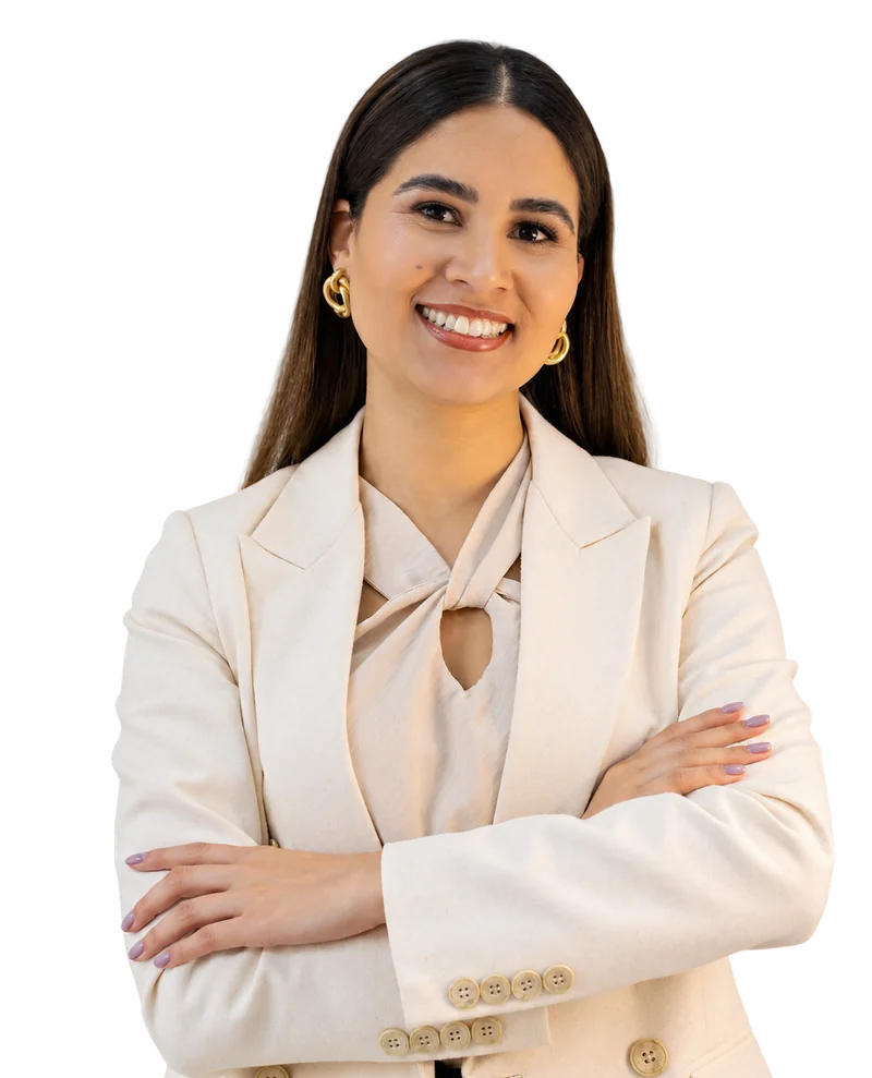 Juliane Souza, professora do curso, sorrindo de braços cruzados